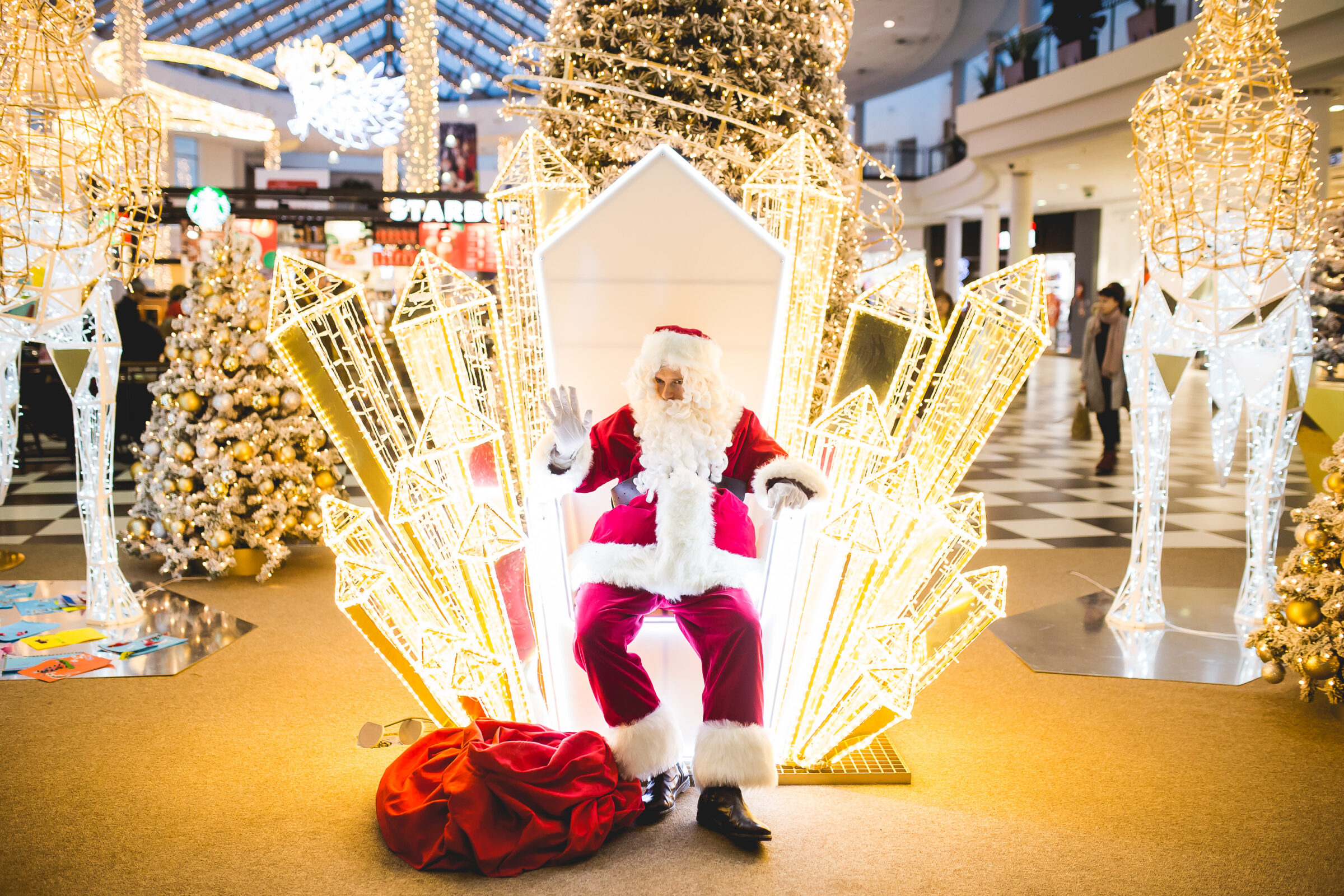 Swięty Mikołaj siedzi na świetlistym tronie i acha do grzecznych dzieci