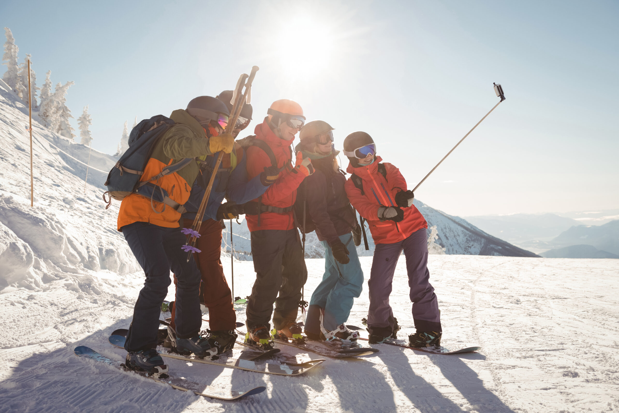 Grupa narciarzy robi sobie selfie na tle góry